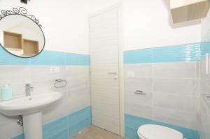 un bagno con lavandino, WC e specchio di Casa Lillì a Ischia