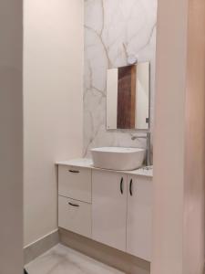 een witte badkamer met een wastafel en een spiegel bij 2 Bedroom Apartment near Vijayanagar, Bangalore in Bangalore