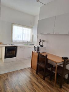 a kitchen with a wooden table and a kitchen with white cabinets at TERPSICHORE Holiday Apts in Limassol