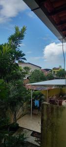 een patio met een witte parasol en een boom bij Hostel Horizonte Ceará in Horizonte