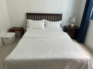 um quarto com uma grande cama branca e uma mesa de cabeceira em Dreamy Sunset Bay em Manila