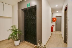 a hallway with a black door with a number on it at OYO Townhouse 591 Hotel Woodland in Nagpur