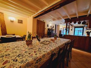 uma sala de jantar com uma mesa com uma toalha de mesa floral em Dri les Courtils em La-Roche-en-Ardenne