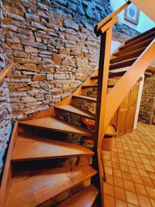 uma escadaria numa parede de pedra com degraus de madeira em Dri les Courtils em La-Roche-en-Ardenne