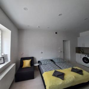 1 dormitorio con 1 cama y 1 silla en Stílus Apartman, en Vásárosnamény