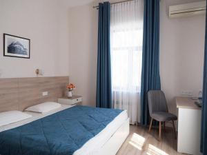Un dormitorio con una cama y un escritorio y una ventana. en Asia Hotel, en Bishkek 60 fotos más