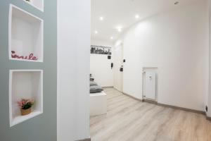 korytarz z białymi ścianami i drewnianą podłogą w obiekcie Due passi dal mare w Genui