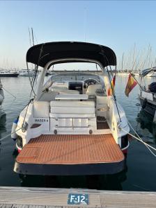 Maser II ( Excelente Mini Yate ) في فالنسيا: قارب أبيض متوقف على رصيف في الماء