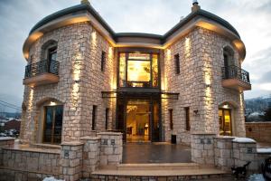 un grande edificio in pietra con luci sopra di Chateau Rond Boutique Hotel & Spa a Kato Loutraki