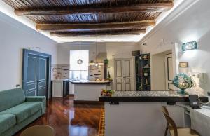 a living room with a green couch and a kitchen at B & B Boutique Epoca in Salerno