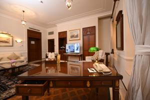 a living room with a desk and a television at The Imperial, New Delhi in New Delhi