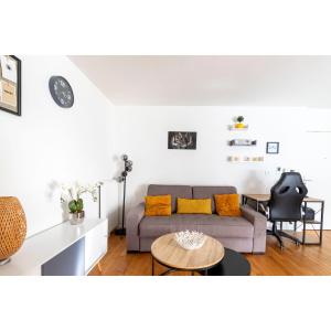uma sala de estar com um sofá e uma mesa em "Spacieux et lumineux" proche Paris em Cachan