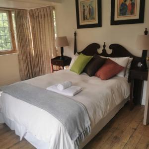 a bedroom with a large bed with two towels on it at Pebble Fountain Guesthouse in Pretoria