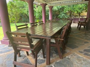 a long wooden table and chairs on a patio at Pebble Fountain Guesthouse in Pretoria