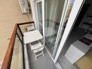 a white table and chair on a balcony at Location Location Location in Sliema