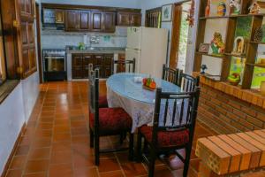 eine Küche mit einem Tisch mit Stühlen und einem Kühlschrank in der Unterkunft Finca Villa Alicia in Barichara