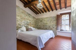 una camera con un letto in una stanza con pareti in pietra di Villa Le Polle di Meletro a Chianni