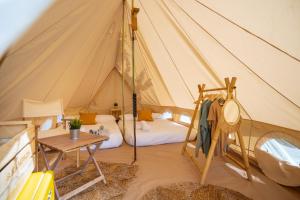 Zimmer mit einem Zelt mit einem Bett und einem Tisch in der Unterkunft Kampaoh Sesimbra in Sesimbra