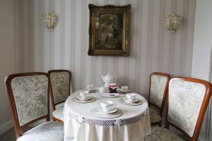 ein Esszimmer mit Tisch und Stühlen und einem Teeservice in der Unterkunft Apartament pałacowy in Świebodzin