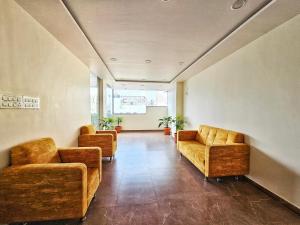 een wachtkamer met banken en stoelen in een gebouw bij Hotel Aaryan Comforts - Peenya in Bangalore