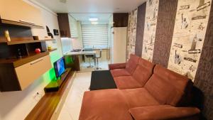 Apartament modern -mobilat nou في Chiajna: غرفة معيشة مع أريكة بنية وطاولة