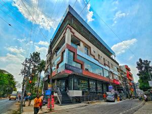 班加罗尔Hotel Aaryan Comforts - Peenya的街道拐角处的建筑物,前面的人在步行