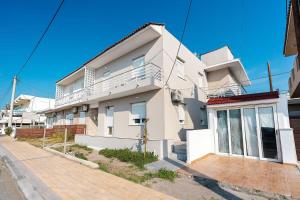 a white apartment building with a balcony on a street at Ciel Rhodes in Rhodes Town