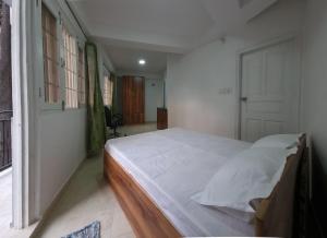 ein Schlafzimmer mit einem großen weißen Bett in einem Zimmer in der Unterkunft TiNY HOMESTAY for International Guest only in Shimla