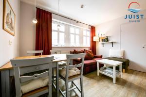 a living room with a table and a couch at Haus Inselresidenz Strandburg 301 - Wohnung 101 in Juist
