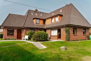 une maison en briques brunes avec une cour verdoyante dans l'établissement Jule im Haus Wega, à Westerland
