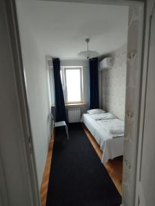 a small bedroom with a bed and a window at Warszawa Apartament z Widokiem in Warsaw