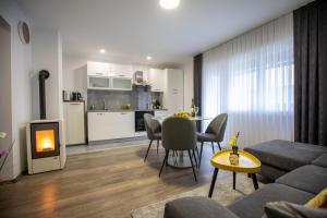 a living room with a couch and a table with a fireplace at Apartmani Tea in Ogulin