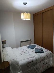 1 dormitorio con 1 cama con 2 toallas en Apartamento El Toboso en Alcalá de Henares