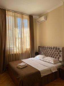 a bedroom with a bed with a large window at Balcony Hotel in Tbilisi City