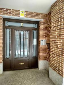 a large wooden door in a brick building at Apartamento El Toboso in Alcalá de Henares