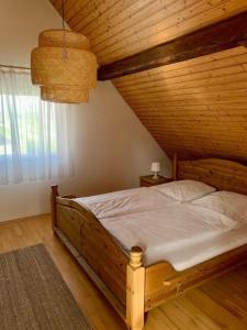 Bett in einem Zimmer mit Holzdecke in der Unterkunft Haus Alkmene in Bodman-Ludwigshafen