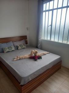 a bed with a teddy bear and flowers on it at Tropical Retreats in Flic-en-Flac