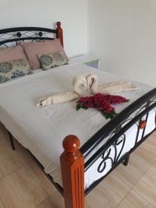 a bed with two teddy bears and flowers on it at Tropical Retreats in Flic-en-Flac