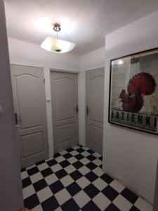 an empty room with a painting on the wall and a checkered floor at Warszawa Apartament z Widokiem in Warsaw