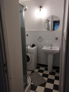 a bathroom with a sink and a toilet and a mirror at Warszawa Apartament z Widokiem in Warsaw