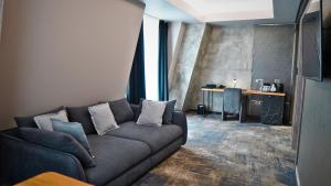 a living room with a couch and a table at Aniroc Signature Hotel in Arad