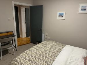 Schlafzimmer mit einem Bett, einem Schreibtisch und einem Tisch in der Unterkunft Dallkey Retreat in Dalkey