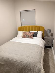 Bett mit gelbem Kopfteil in einem Schlafzimmer in der Unterkunft Dallkey Retreat in Dalkey