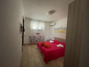 a bedroom with a red bed with towels on it at B&B Francesca in Scorrano