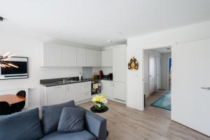uma sala de estar com um sofá azul e uma cozinha em Lovely 1-Bed Apartment in London em Londres