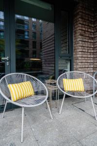 two chairs with yellow and white pillows sitting in front of a building at Lovely 1-Bed Apartment in London in London