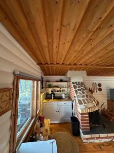 a kitchen and living room with a wooden ceiling at Kenttäpirtti in Kittilä