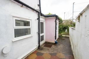 an alley with a pink house and a window at Stylish 1-Bed Flat in Bristol in Bristol