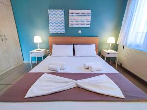 a bedroom with a large bed with white sheets and pillows at CityZEN View - Retro Nest in Argostoli