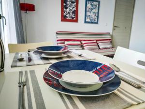 a table with plates and utensils on a table at CityZEN Apartment with a View in Argostoli